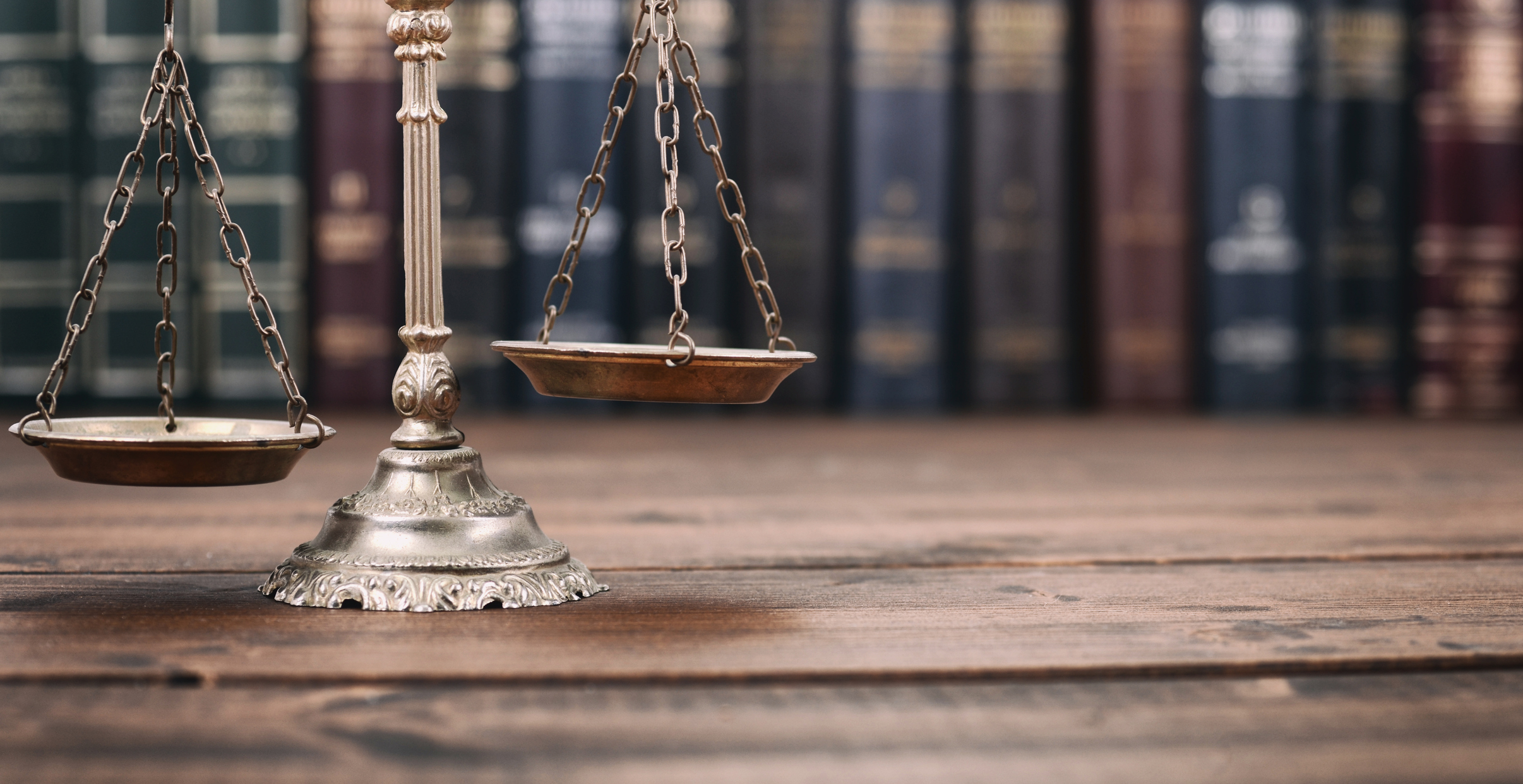 Scales of Justice and Law books on a  wooden background.